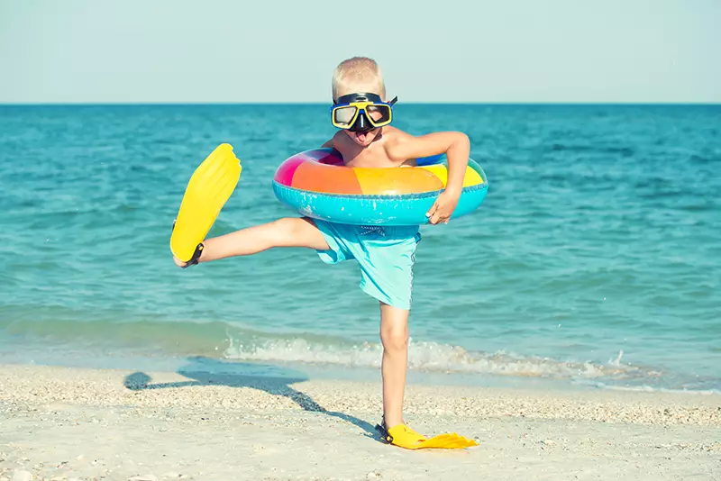 Bub mit Flossen und Schwimmreifen